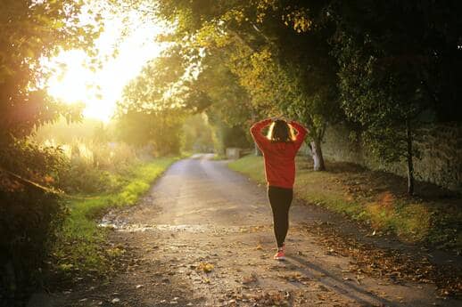 woman walking down a path in the morning